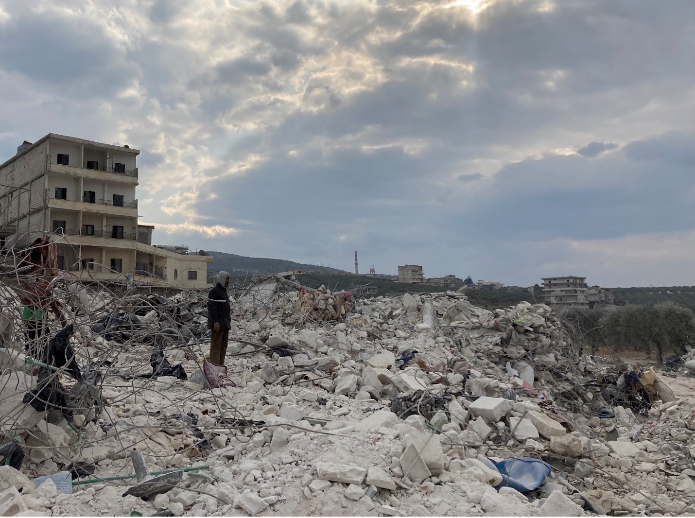 Cover photo: A man watches on as a family sifts through their destroyed home looking for blankets and clothes. Photo by Gregory Waters.