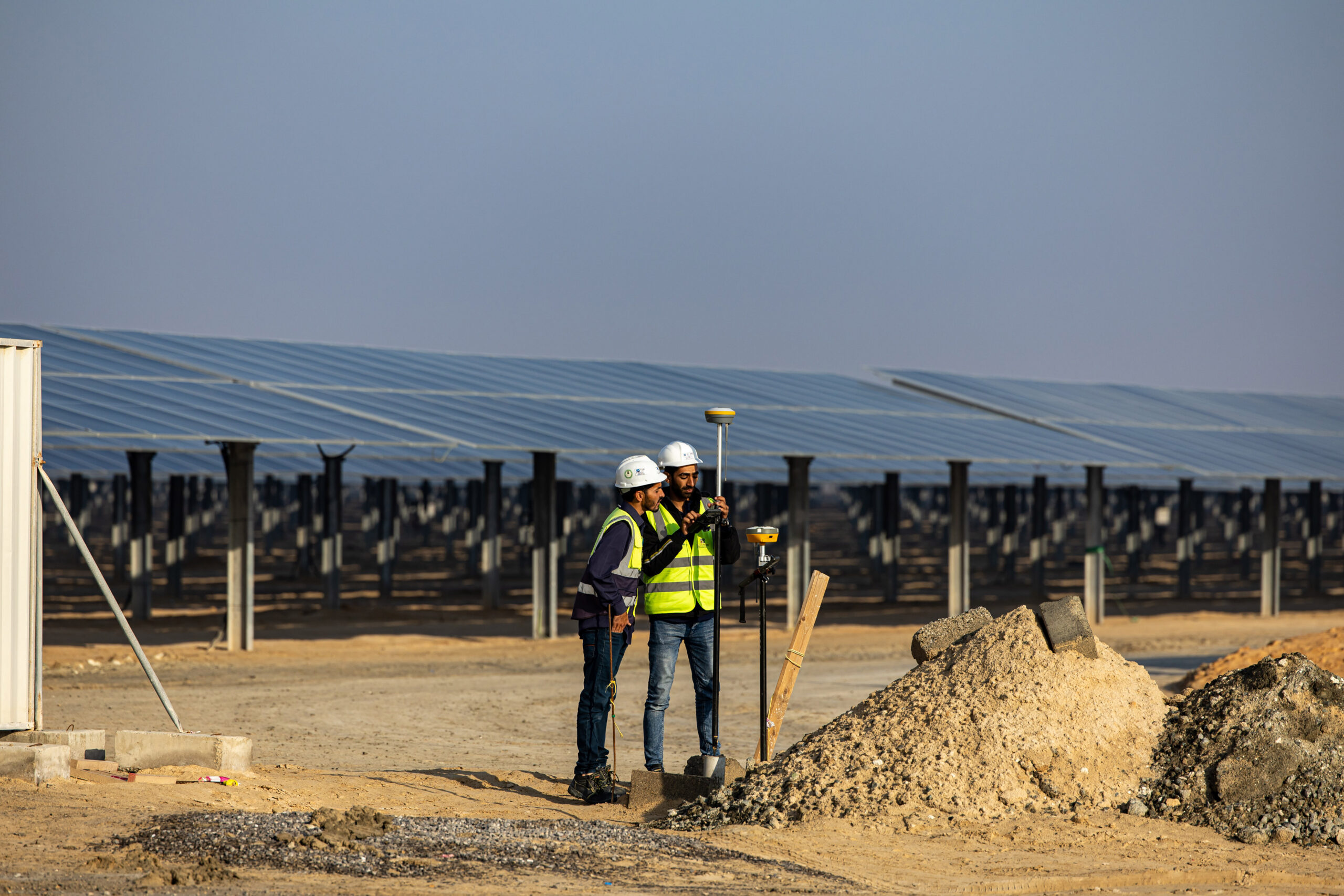 Workers install equipment at al-Dhafra solar project, constructed by Electricite de France and Jinko Power Technology, in Abu Dhabi, on January 31, 2023. Photo by Christopher Pike/Bloomberg/via Getty Images.