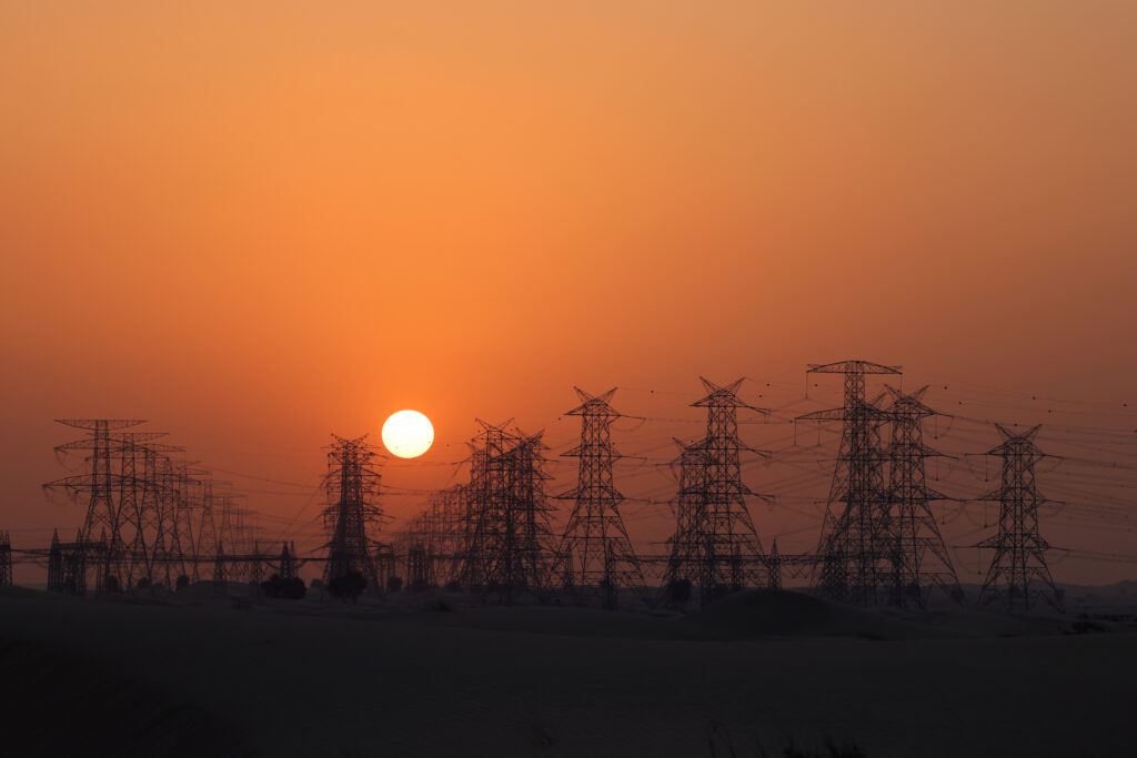 TOPSHOT - A picture taken at sunset on October 30, 2021, shows high-voltage pylons in the emirate of Dubai, in the United Arab Emirates. (Photo by Giuseppe CACACE / AFP) (Photo by GIUSEPPE CACACE/AFP via Getty Images)