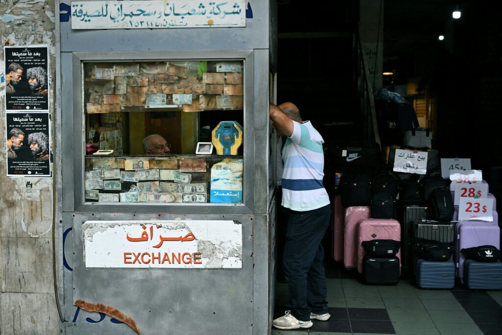 Photo above: A client stands at a currency exchange office in Beirut on November 14, 2025. Source: Photo by Joseph EID / AFP via Getty Images.