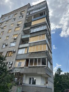 Apartment building with plywood on windows in Ukraine. Photo by Ryan Crocker.