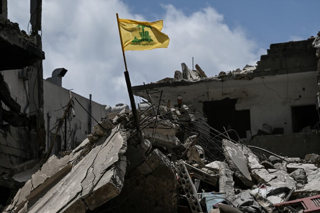 A yellow flag belonging to Hizballah flutters on top of the rubble of a building in the southern Lebanese coastal city of Tyre on June 23, 2026.Photo by Joseph EID/AFP via Getty Images.