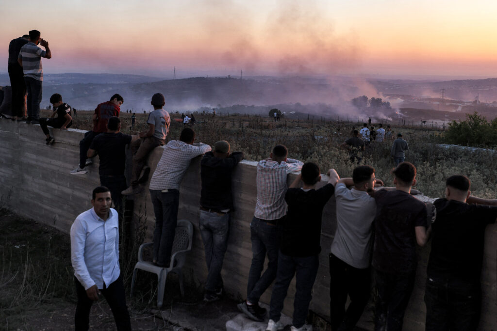 Palestinians watch as a fire blazes near the village of Tell, adjacent to the Israeli settlement of Havat Gilad, west of Nablus inthe occupied West Bank on July 18, 2026, after a reported arson attack by Israeli settlers. Source: Jaafar Ashtiyeh/AFP via Getty Images.